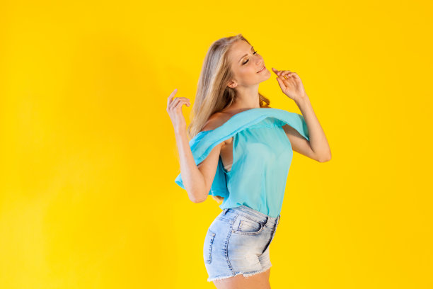 金发女孩穿着蓝色裙子，背景是黄色图片下载