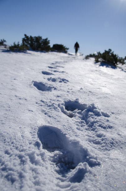 山上雪地上一个徒步旅行者的脚印图片下载