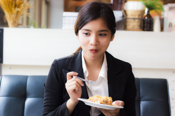 亚洲商务女性在休闲时间和吃苹果派在咖啡店。用来吃派的手握勺子。苹果派，不同地区的苹果挞，主要馅料是苹果。图片下载