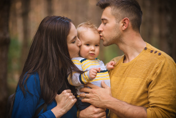 一对年轻夫妇带着一个小男孩走着图片下载