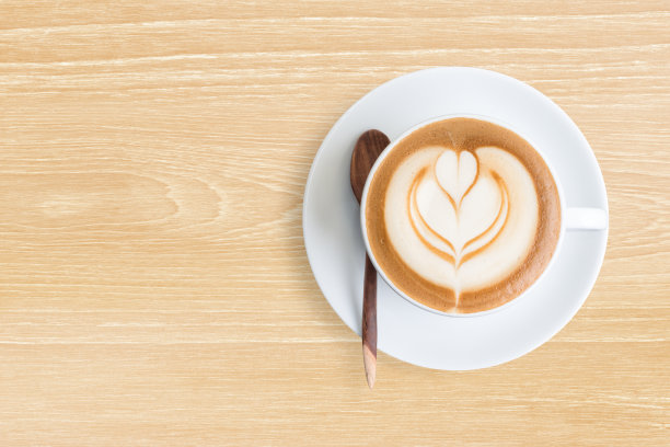 一杯拿铁咖啡在柚木桌子上俯视图图片下载