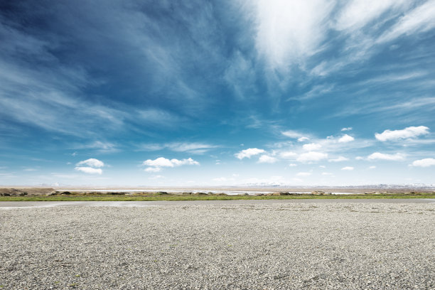 空旷的泥地，蓝天下的雪山图片下载