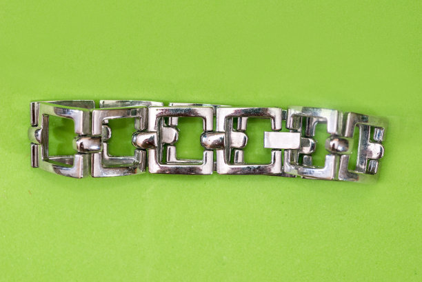 不锈钢或银手镯，为女性隔离在绿色背景图片下载