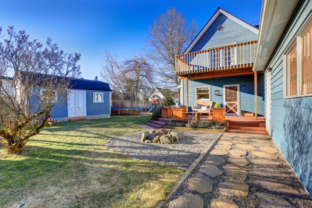 蓝色工匠住宅的外观，带有带顶的后门廊，火坑和玩具。图片下载