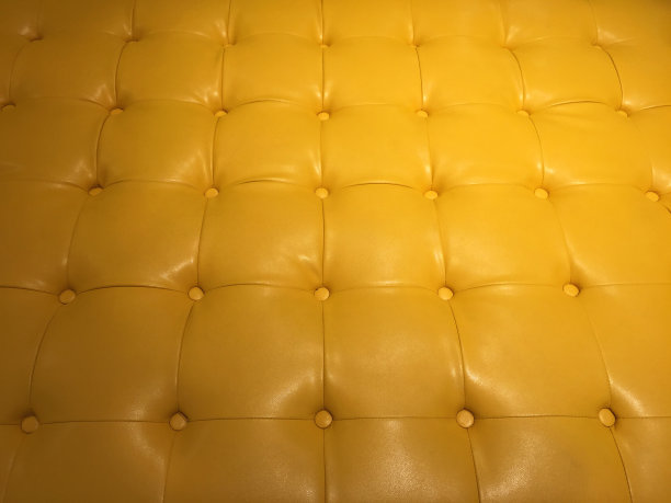 黄色合成皮革沙发与钮扣纹理图片下载