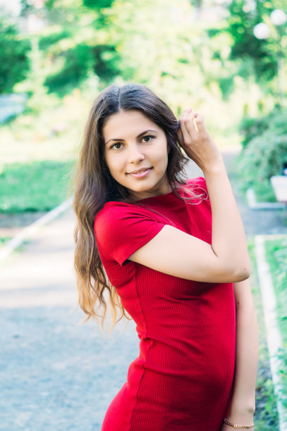 美丽的女孩模型在一个公园的道路上摆姿势的照片相机在红色板图片下载