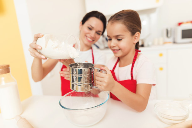妈妈和小女儿在家里的厨房里一起做饭。图片下载