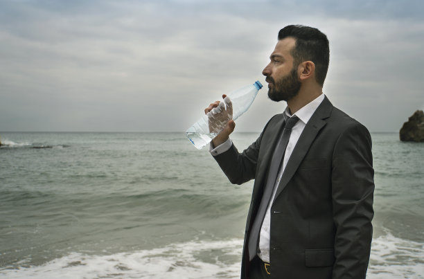 口渴的商人在海边喝水图片下载