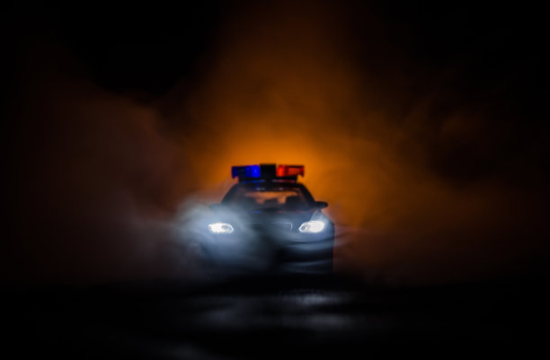 一辆警车在雾中追赶一辆汽车。911紧急反应警车超速驶往犯罪现场图片下载