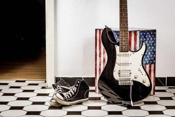 电吉他，皮夹克和运动鞋躺在地板上图片下载