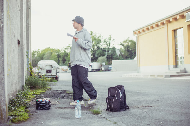 年轻的涂鸦艺术家看着他的不完整的涂鸦图片下载