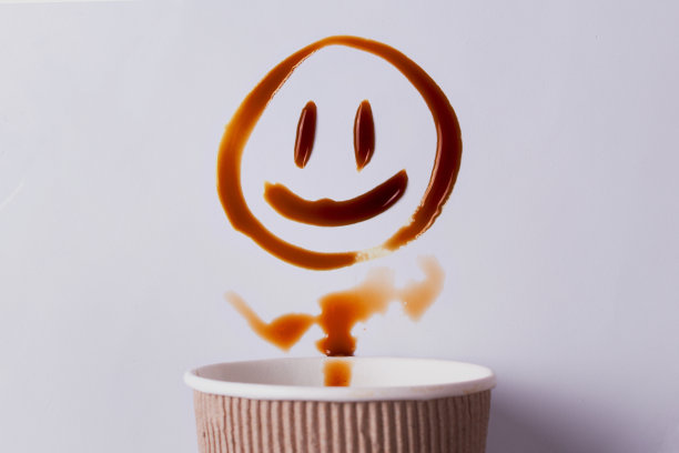 咖啡的形式是微笑。咖啡杯和洒出来的咖啡图片下载