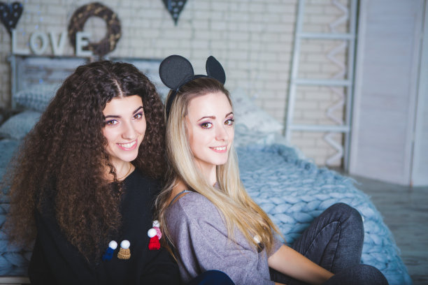 两个快乐的美丽的长卷发的女人的肖像。感受新的一年。圣诞快乐图片下载