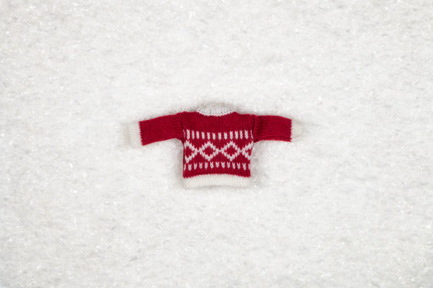 白色的雪背景上编织着红色的圣诞和新年毛衣。图片下载