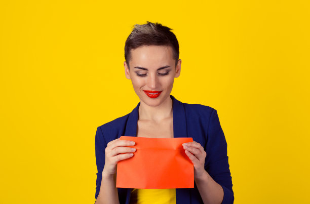全新的邮件贿赂概念。特写肖像商务女性在蓝色正式西装，衬衫收到一个信封看里面好奇高兴，她看到孤立的黄色背景与复制空间图片下载