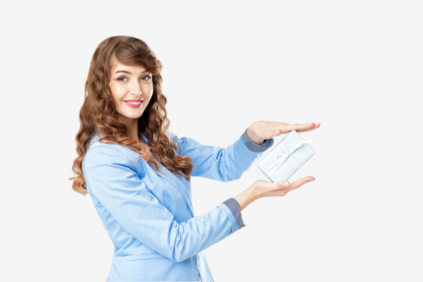 穿着夹克的漂亮女人拿着礼盒。图片下载