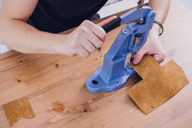 皮革工匠在工作室的桌子上工作，制作产品图片下载