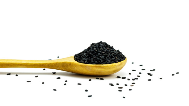 黑芝麻配木勺，白色背景。构图孤立在白色背景上。图片下载