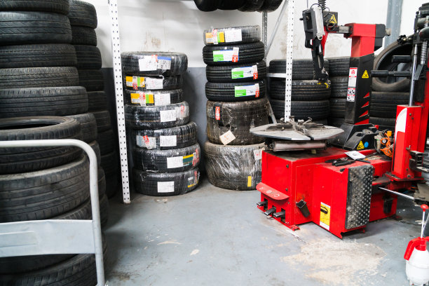 汽车修理店里堆放的一摞新橡胶轮胎图片下载