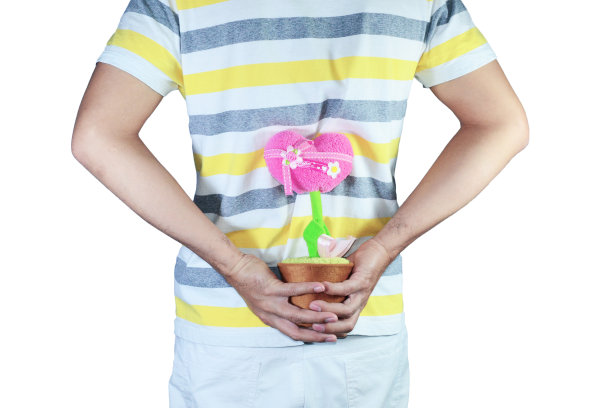 一名男子穿着一件t恤，将一个粉红色的心形花盆藏在白色的背景上图片下载