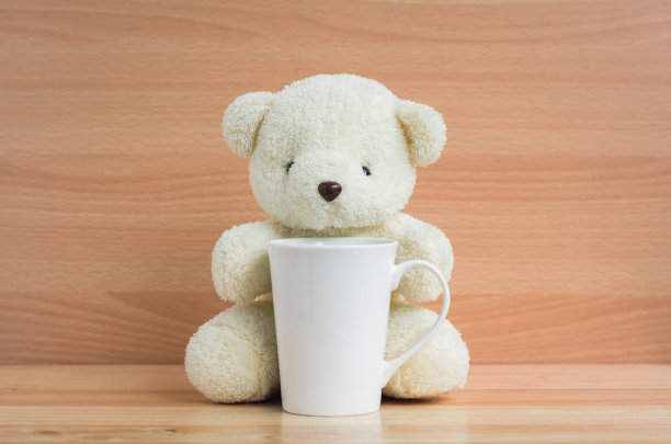 熊和杯子在棕色的木头背景图片下载