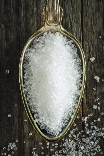 一勺细砂糖放在木质背景上素材图片