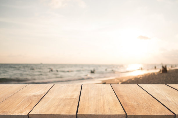 空木桌和模糊的日落海滩背景图片下载