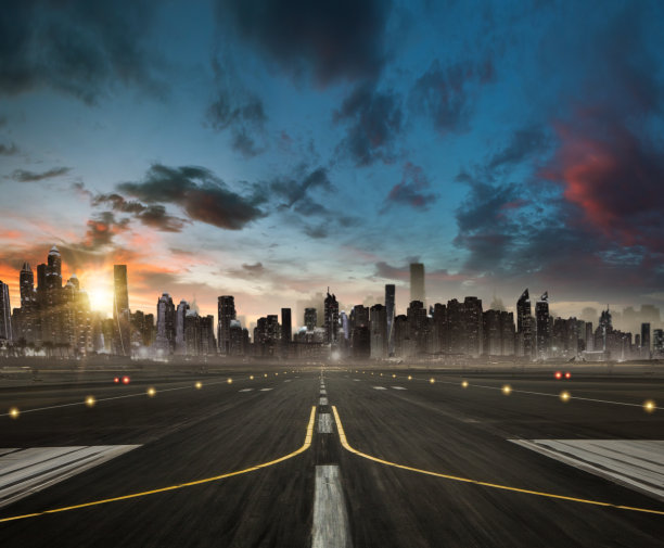 通往现代化高楼林立城市的空旷飞机跑道图片下载