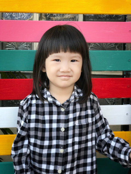 亚洲小女孩微笑与多颜色的木制背景图片下载