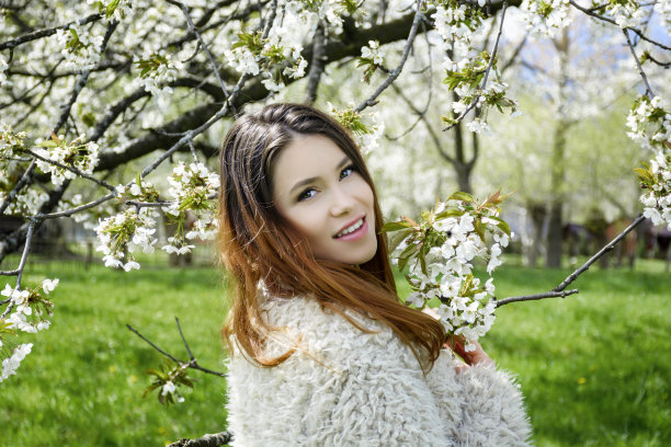 美丽的金发女郎站在盛开的树旁图片下载