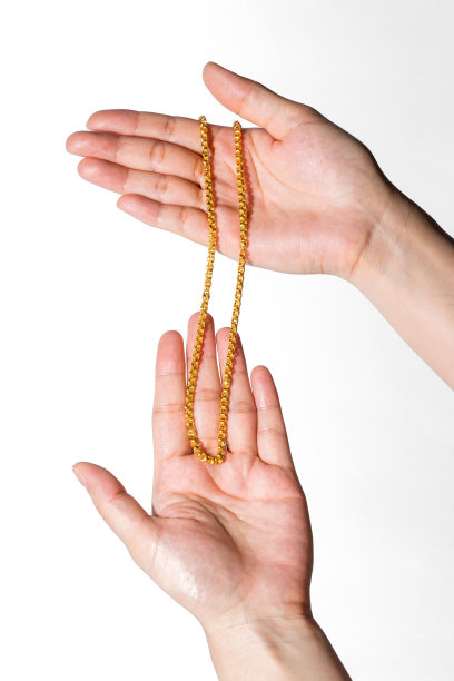 女人一直拿着金项链，孤立白色背景。图片下载