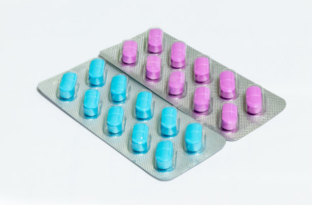 一个包装粉红色和一个包装蓝色椭圆形药丸孤立在白色背景图片下载