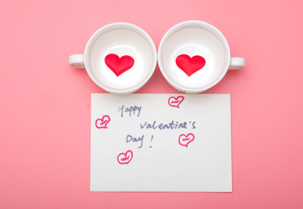 拟人化的脸，杯子和明信片在粉红色的背景，情人节的背景素材图片