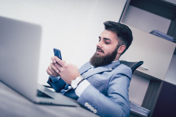 在办公室用电脑发短信的大胡子商人图片下载