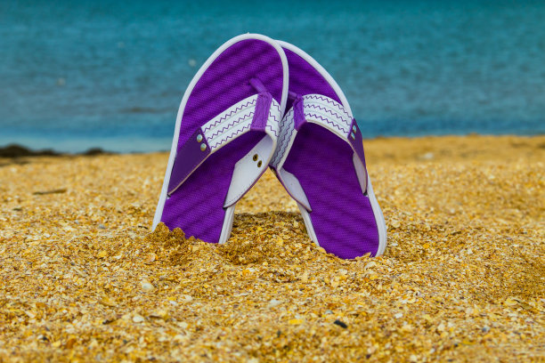 一双翘在沙滩上的人字拖图片下载