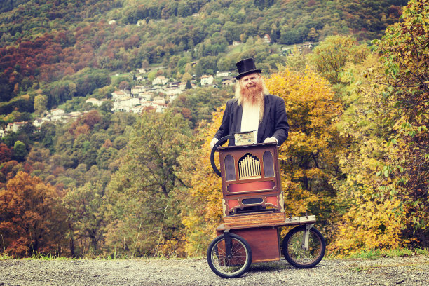 红头发和胡子优雅的男人玩他的推车风琴图片下载