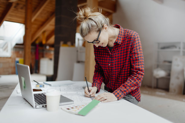 年轻漂亮的金发女人正打算用笔记本和平板电脑扩建她的阁楼图片下载