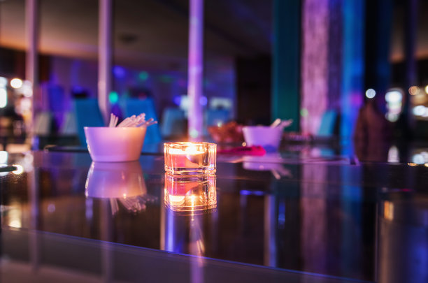 被灯光照亮的玻璃棒上燃烧的蜡烛图片下载