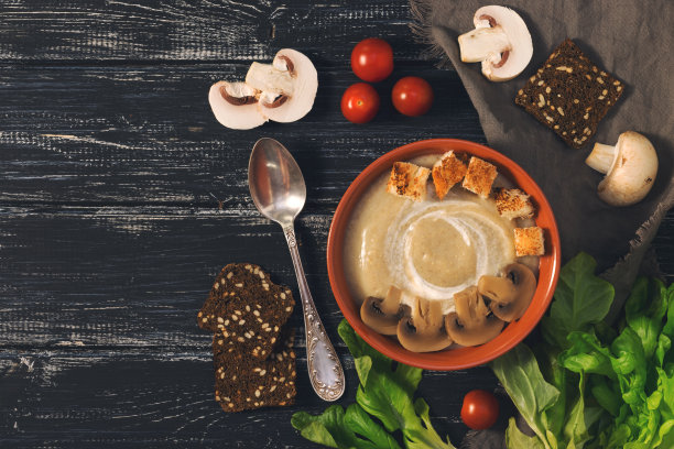 奶油蘑菇汤，田园背景，生菜和黑麦面包屑。照片与色调，俯视图。图片下载