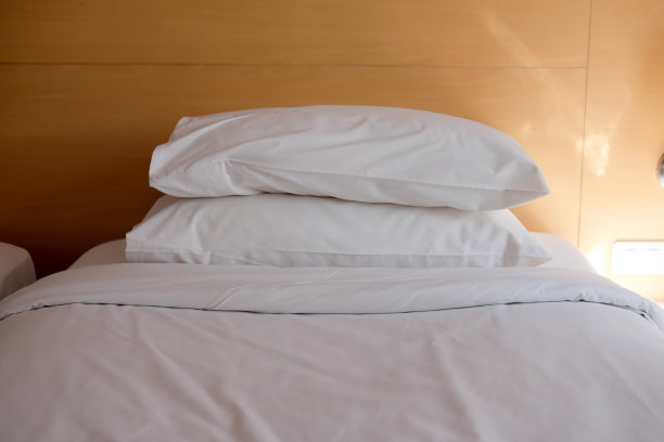 枕头堆在简单的白色床上图片下载