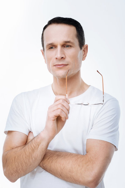 英俊体贴的男人拿着他的眼镜图片下载