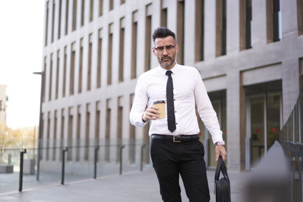 帅气、成熟、成功的高管，拿着公文包在小午休时间喝着咖啡，忙碌的工作日程安排着一天的工作，匆匆赶去新闻发布会，汇报工作成果图片下载