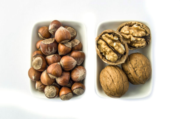 核桃和去壳的榛子图片并排放在一个单独的盘子里，并排放在去壳的榛子和去壳的核桃图片里图片下载