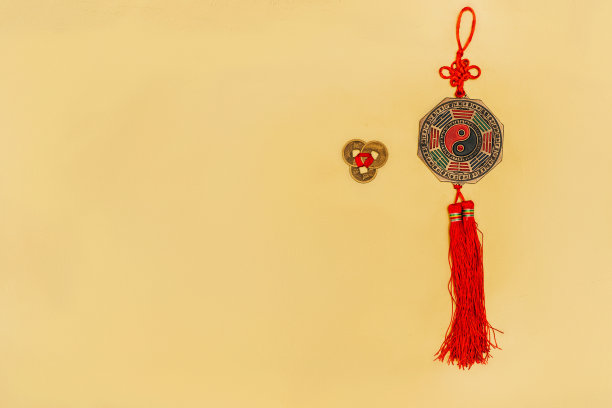 黄色背景上的中国阴阳护身符和硬币俯视图素材图片