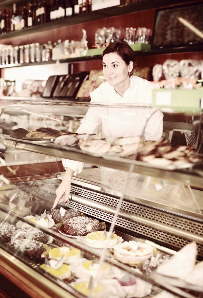 年轻的女助理帮助选择甜点图片下载