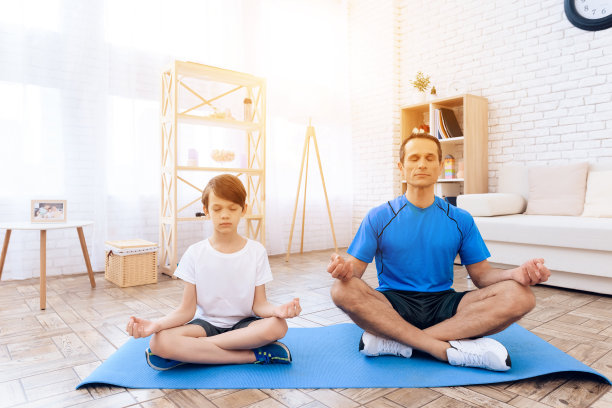 那个男人和那个男孩正在练瑜伽。素材图片