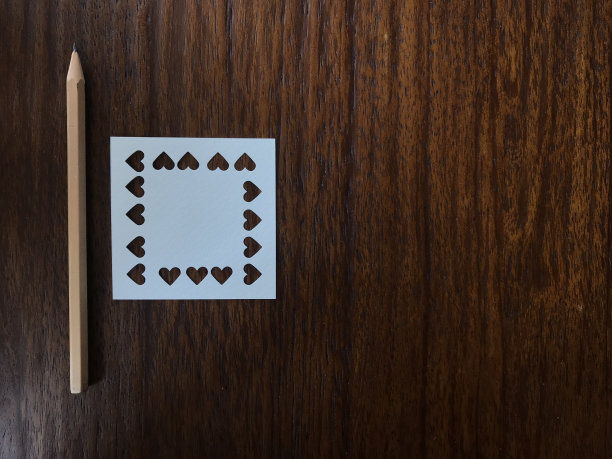 铅笔和白纸被打成心形放在桌上图片下载