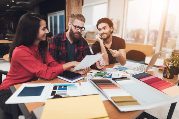 设计师和他的客户正在考虑纸上的设计项目。图片下载