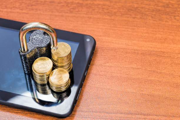 平板电脑上的挂锁和金币。数据安全概念图片下载