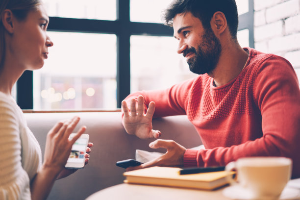 相爱的情侣讨论周末的计划，通过现代手机上的在线应用程序搜索酒店，快乐的最好的朋友在社交网络上分享共同的照片在咖啡馆休息图片下载